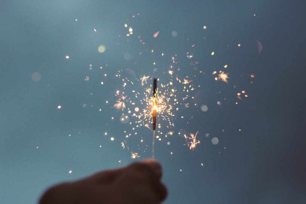 a sparkler held against a dark sky